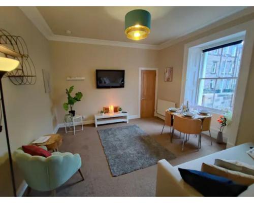 uma sala de estar com um sofá e uma mesa em Central Edinburgh Private Garden with parking em Edimburgo