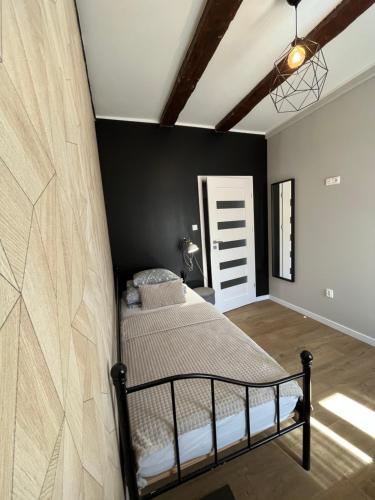 a bedroom with a bed and a wall at Apartamenty Dobranocka in Krotoszyn
