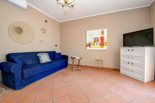 a living room with a blue couch and a tv at Prestige rooms in Sirmione
