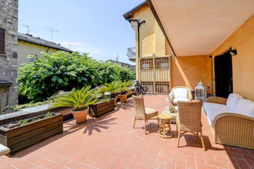 a patio with chairs and a couch on a patio at Prestige rooms in Sirmione