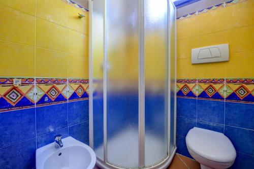 a bathroom with a shower and a toilet and a sink at Prestige rooms in Sirmione