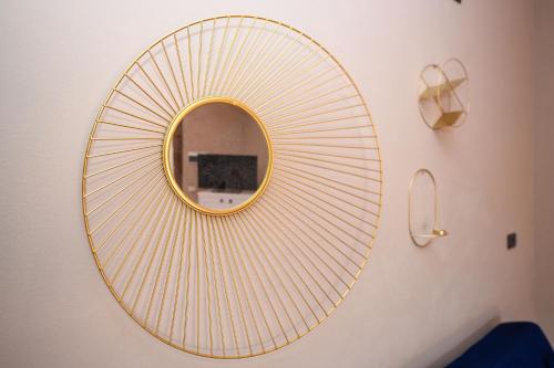 a round mirror on a wall with a gold rim at Prestige rooms in Sirmione