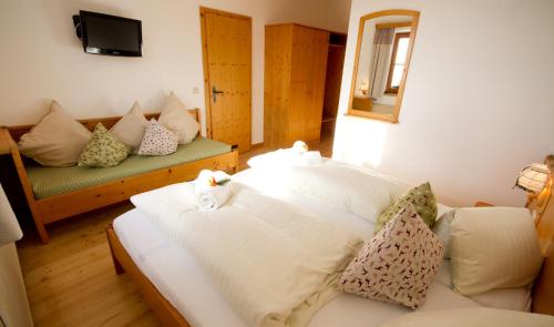 a room with a couch and two cats sitting on a bed at AlmDorf Tonnerhütte in Mühlen