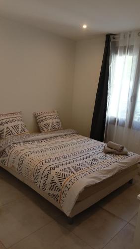 un grand lit dans une chambre avec une fenêtre dans l'établissement Charmante maison de ville avec parking privé, à Nîmes