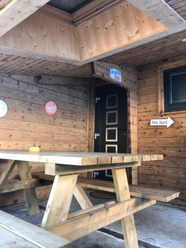 - une table de pique-nique à l'avant d'une cabane en rondins dans l'établissement Chalet Le Vintage, à La Bresse