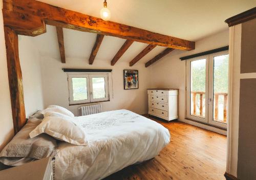 um quarto com uma cama, uma cómoda e janelas em Casa de Campo La Solana em Estollo