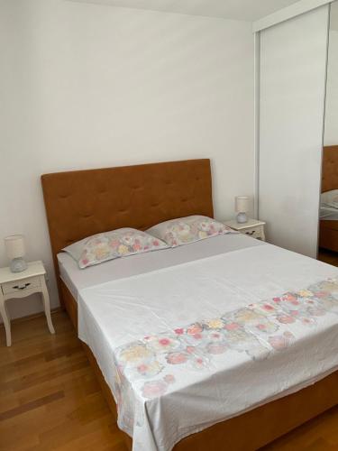 a bedroom with a large white bed with flowers on it at Apartmani Mia in Kali