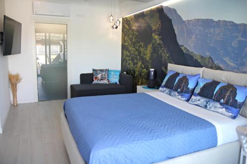 1 dormitorio con 1 cama azul y 1 silla en Room Capri en SantʼAntonio Abate