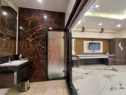 La salle de bains est pourvue d'une douche et d'un lavabo. dans l'établissement Grand Beach Resort, à Mandarmoni