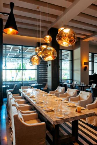 a long table in a restaurant with chairs and lights at Secrets Moxché Playa del Carmen - Adults Only - All Inclusive in Playa del Carmen