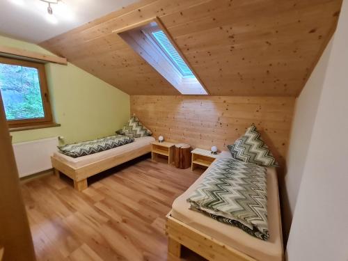 an attic room with two beds and a window at Appartement Gsaller in Hopfgarten in Defereggen