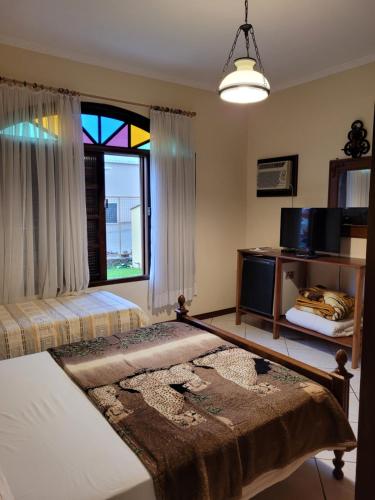a bedroom with a bed and a stained glass window at Pousada Bella Vista in Gravatal