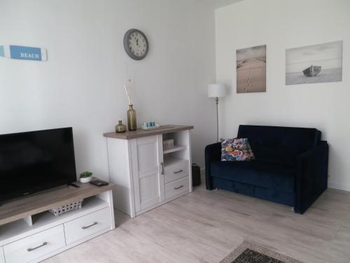 a living room with a black chair and a television at Studio Verdemar Nexo in Puck