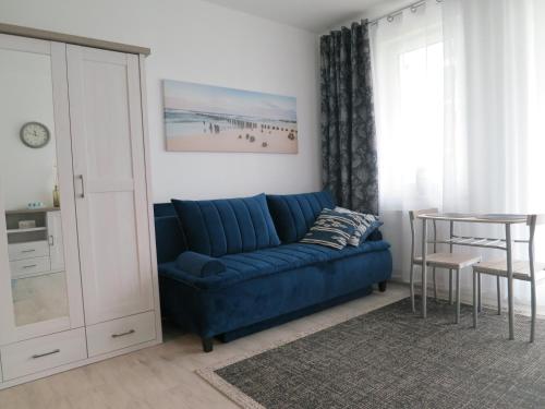 a living room with a blue couch and a table at Studio Verdemar Nexo in Puck