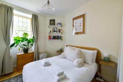 a bedroom with a bed with white sheets and a window at GuestReady - Picturesque 1BD Home in Dean Village in Edinburgh