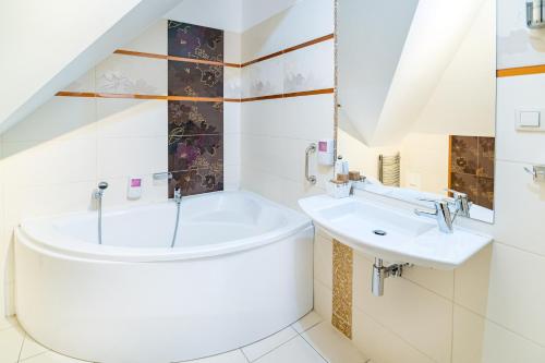 a bathroom with a tub and a sink at Hotel Pod Filarami in Czeladź