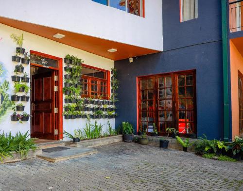 a blue and white building with a door and plants at Funk Bunks - Mount View in Kandy