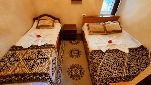 a room with two beds with white sheets at Zheenkan2 in Naryn