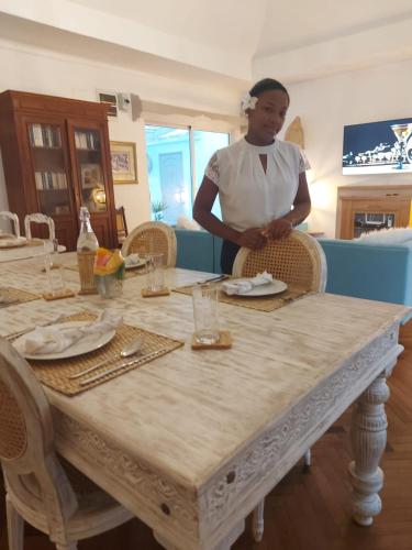 a woman standing in front of a table at Au Temps D'antan- Ile Rodrigues in Rodrigues Island