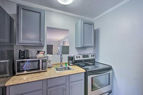 a kitchen with a microwave oven and a sink at Cozy Studio Cabin on Lake O the Pines with Deck! in Avinger