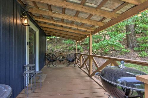 a porch with two chairs and a table on it at Cozy Studio Cabin on Lake O the Pines with Deck! in Avinger