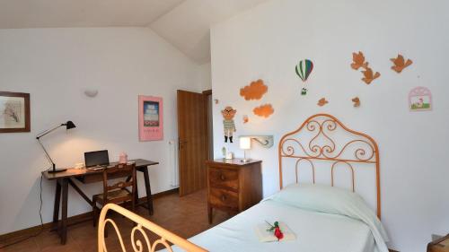 a bedroom with a bed and a desk with a laptop at Podere Firenzuola in Orvieto