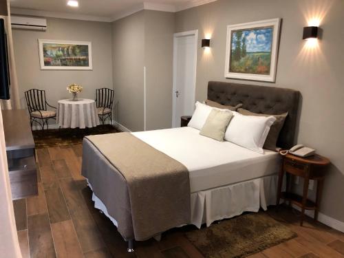 Lagoa Parque Hotel في لاجوا فيرميلها: غرفة نوم بسرير وطاولة مع كراسي