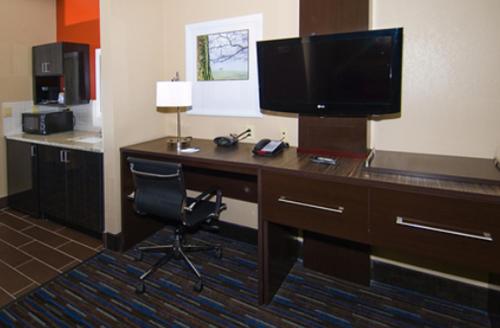 a desk with a television and a chair in a hotel room at Holiday Inn Express Fulton by IHG in Fulton