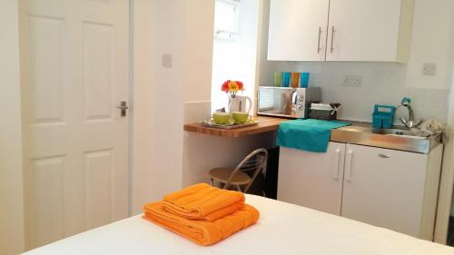 una cocina con una toalla naranja en una encimera en The Jorvik Mini studio with Parking en York