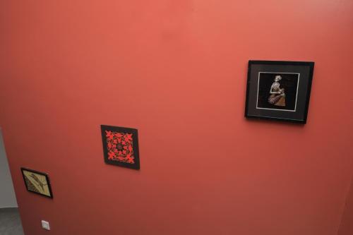 an orange wall with pictures hanging on it at SILVER OAKS HOTEL Boma in Fort Portal
