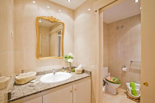 a bathroom with a sink and a mirror and a toilet at Apartment Eixample Comfort in Barcelona