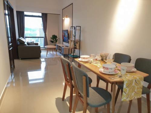 a dining table and chairs in a living room at KL Times Square Apartment in Kuala Lumpur
