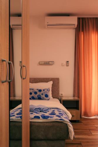 a bedroom with a bed with blue and white sheets at Restoran & Motel Manjež in Bijelo Polje