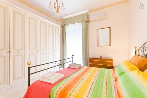 een slaapkamer met een bed met een kleurrijke deken bij Appartamento Vacanze Taormina in Taormina