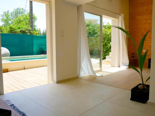 un salon avec une porte coulissante en verre et une plante dans l'établissement Home le Vissou, à Cabrières