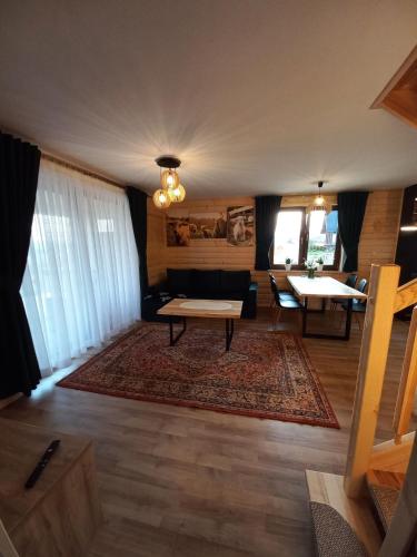 a living room with a couch and a table at Domek na Hubce II in Maniowy