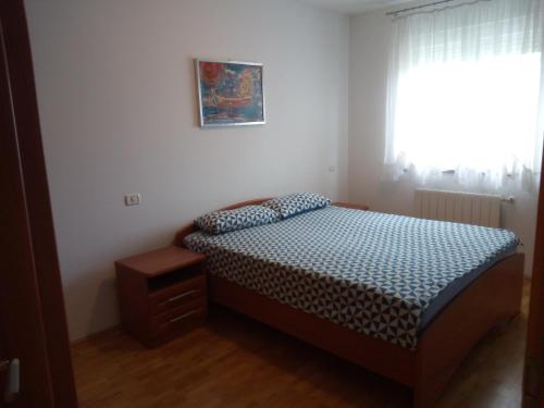 um pequeno quarto com uma cama e uma janela em Petar em Pula