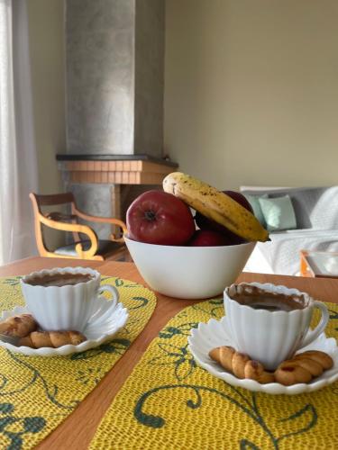 a table with a bowl of fruit and plates of food at Lenio’s in Karistos