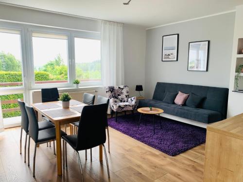 a living room with a blue couch and a table at Sunny Apartament in Pustkowo