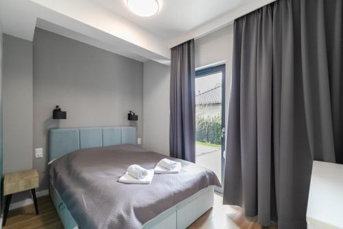 een slaapkamer met een bed met twee handdoeken erop bij Apartament Kochanowskiego z ogródkiem i garażem - Dream Apart in Ustroń