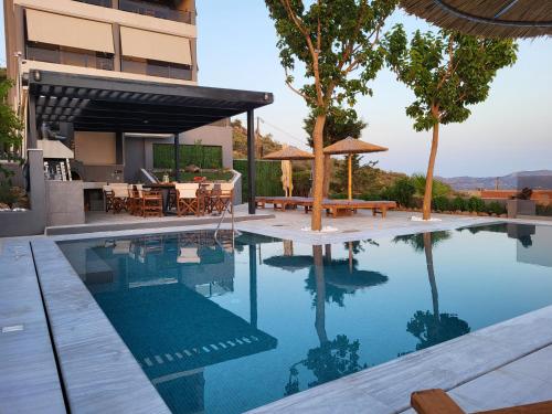 - une piscine en face d'une maison dans l'établissement ''Stergiou Luxury Apartments'' με κοινη πισινα, à Saronida