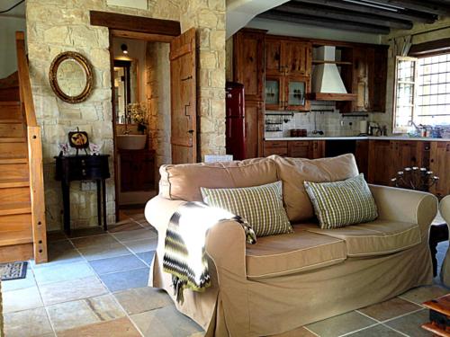 a living room with a couch and a kitchen at Lofou Traditional Stone House in Lofou