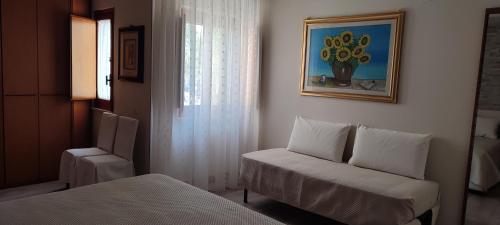 a room with a bed and a chair and a window at Dimora Il Tulipano in Vieste