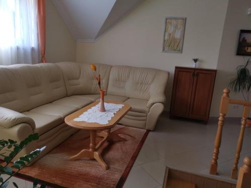 a living room with a couch and a table at Harmónia Panzió in Sárospatak