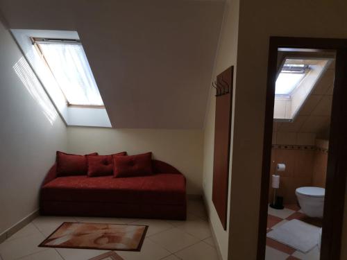 a bedroom with a bed and a bathroom with skylights at Harmónia Panzió in Sárospatak