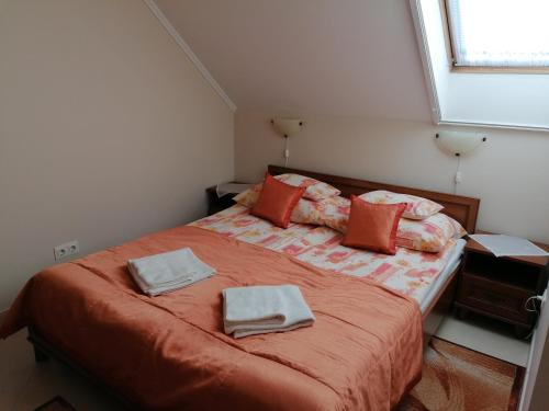 a bedroom with a bed with two towels on it at Harmónia Panzió in Sárospatak