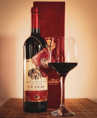 a bottle of wine next to a glass of wine at Restoran & Motel Manjež in Bijelo Polje