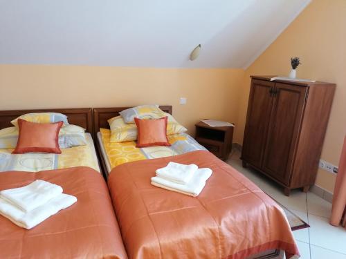 two beds sitting next to each other in a room at Harmónia Panzió in Sárospatak