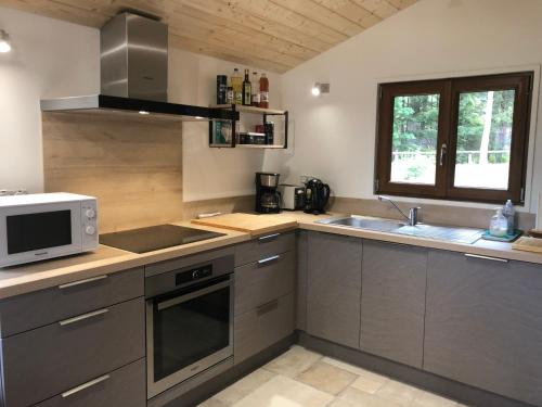 a kitchen with a microwave oven and a sink at Chalet CHLOE - jusque 6 pers - Xonrupt Longemer in Xonrupt-Longemer