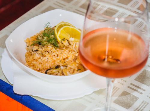 a bowl of rice and a glass of wine at Restoran & Motel Manjež in Bijelo Polje